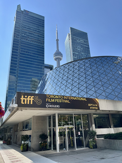 The CN Tower in the background and The Roy Thomson Hall in front with the tiff 50 Rogers banner